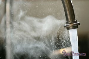 Hot Water Steams From a Faucet.